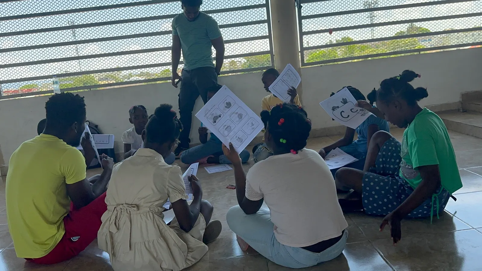 Children practicing English letters with worksheets